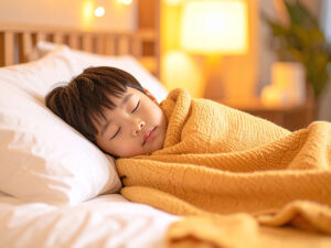 ベッドで眠る小さな男の子