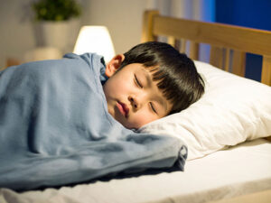 ベッドで眠る小さな男の子