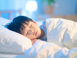 ベッドで眠る小さな男の子