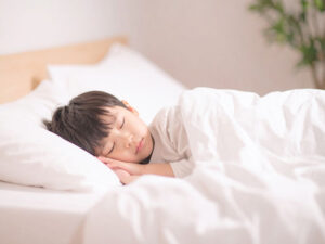 ベッドで眠る小さな男の子