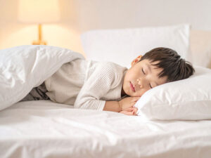 ベッドで眠る小さな男の子