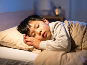 ベッドで眠る小さな男の子