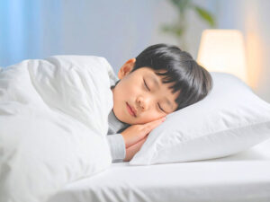 ベッドで眠る小さな男の子