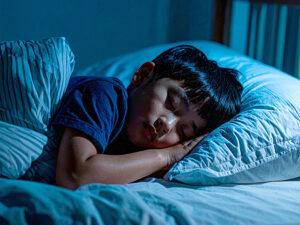 ベッドで眠る小さな男の子