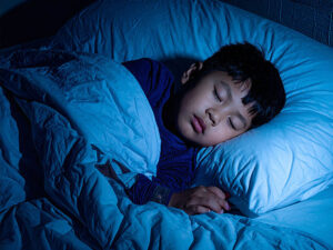 ベッドで眠る小さな男の子
