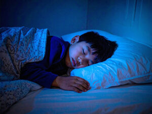 ベッドで眠る小さな男の子