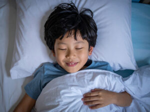 ベッドで眠る小さな男の子