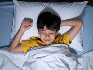ベッドで眠る小さな男の子