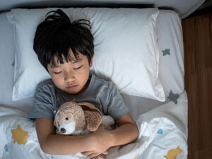 ベッドで眠る小さな男の子