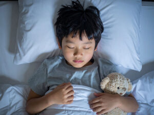 ベッドで眠る小さな男の子