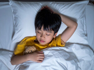 ベッドで眠る小さな男の子