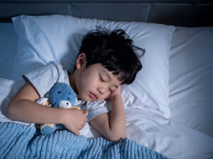 ベッドで眠る小さな男の子