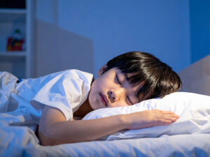 ベッドで眠る小さな男の子