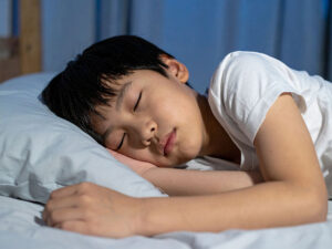 ベッドで眠る小さな男の子