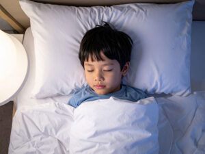 ベッドで眠る小さな男の子