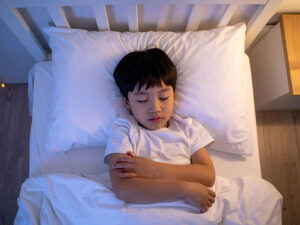 ベッドで眠る小さな男の子