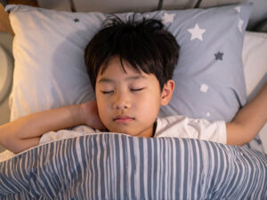 ベッドで眠る小さな男の子