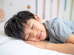 ベッドで眠る小さな男の子