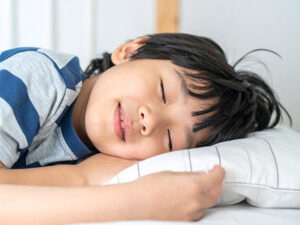 ベッドで眠る小さな男の子