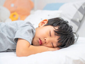 ベッドで眠る小さな男の子