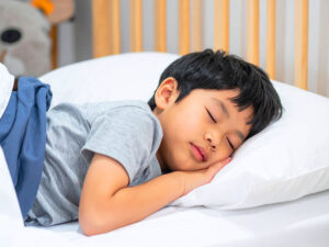ベッドで眠る小さな男の子