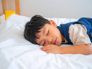 ベッドで眠る小さな男の子