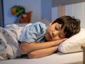 ベッドで眠る小さな男の子