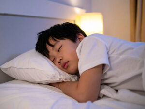 ベッドで眠る小さな男の子