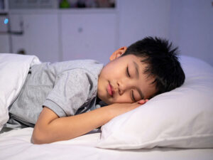 ベッドで眠る小さな男の子