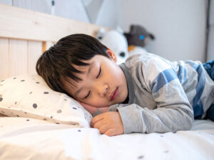 ベッドで眠る小さな男の子