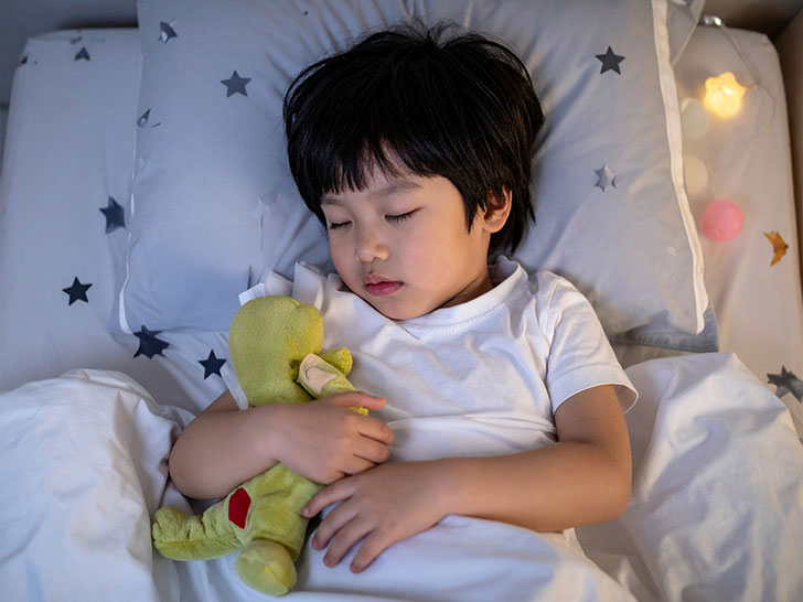 ベッドで眠る小さな男の子