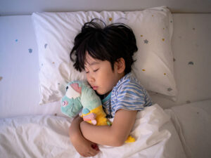 ベッドで眠る小さな男の子