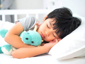 ベッドで眠る小さな男の子