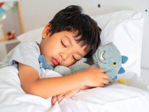 ベッドで眠る小さな男の子
