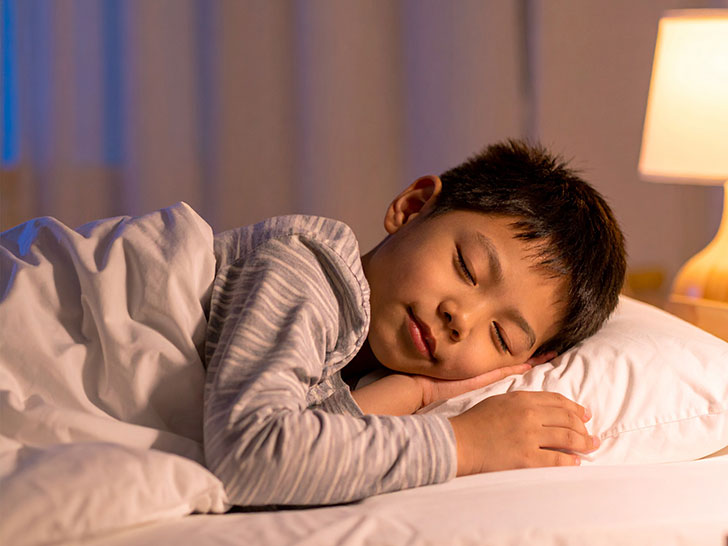 ベッドで眠る小さな男の子