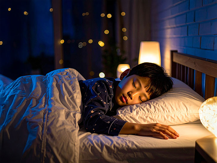 ベッドで眠る小さな男の子