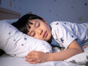 ベッドで眠る小さな男の子