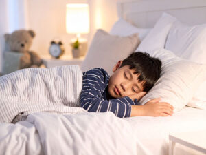 ベッドで眠る小さな男の子