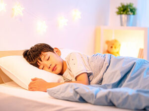 ベッドで眠る小さな男の子