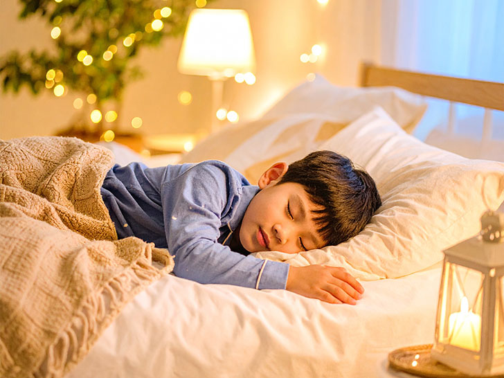 ベッドで眠る小さな男の子