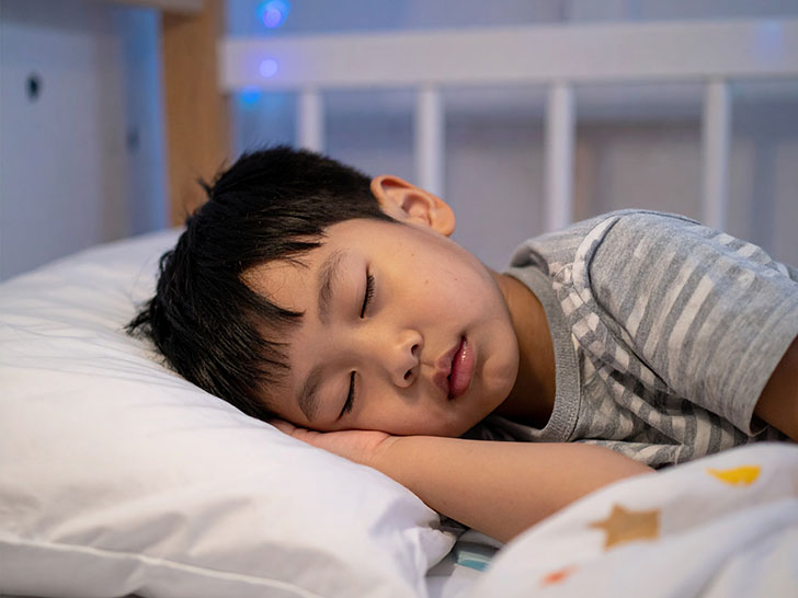 ベッドで眠る小さな男の子
