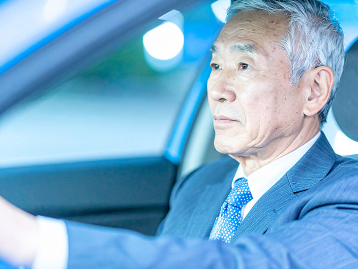 車を運転する年配の男性