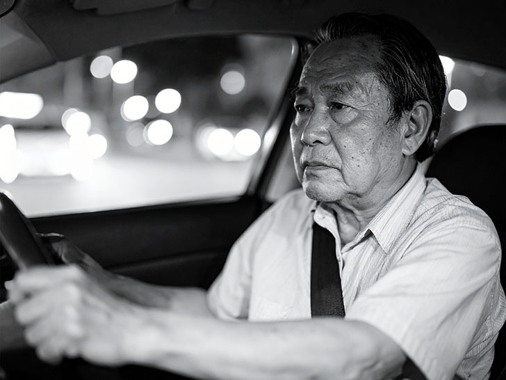 車を運転する年配の男性