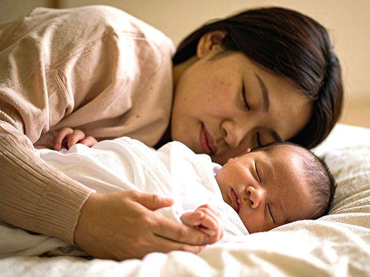 赤ちゃんと一緒に眠るお母さん