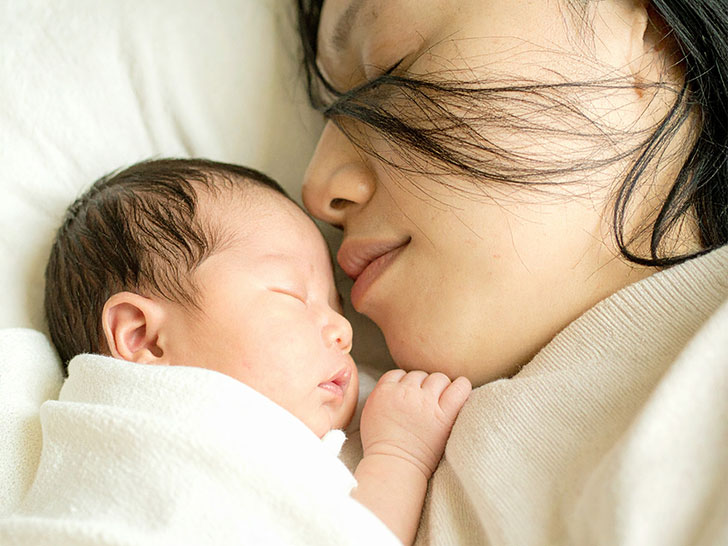 赤ちゃんと一緒に眠るお母さん