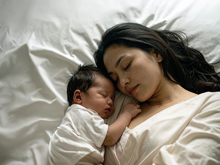 赤ちゃんと一緒に眠るお母さん