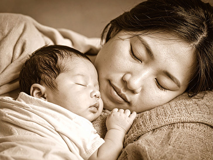 赤ちゃんと一緒に眠るお母さん