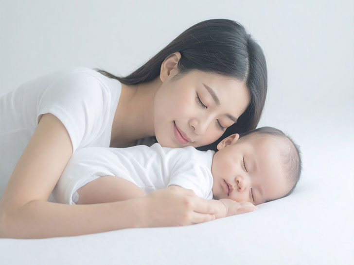 赤ちゃんと一緒に眠るお母さん