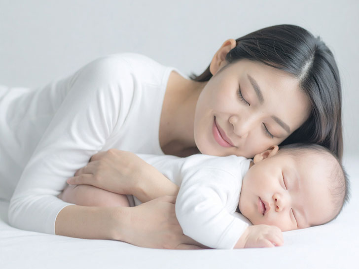 赤ちゃんと一緒に眠るお母さん