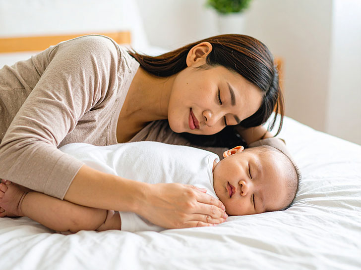 赤ちゃんと一緒に眠るお母さん
